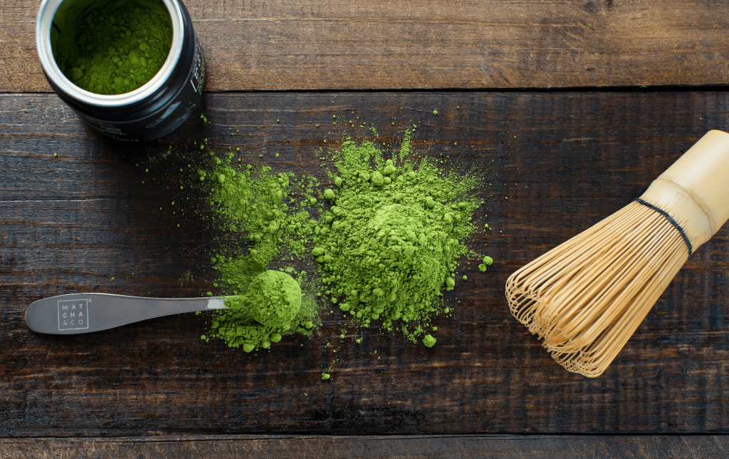 Matcha powder with a spoon and traditional whisk.